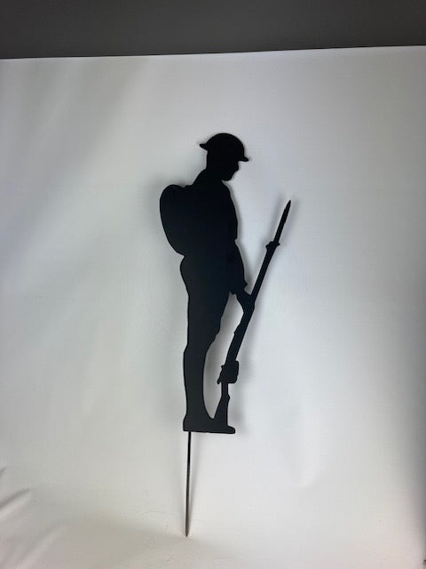 Black metal silhouette of soldier with backpack, gun and helmet solemnly looking down in respect of their fallen comrades. Made from strong 2mm thick metal and finished in a rust proof silk paint.