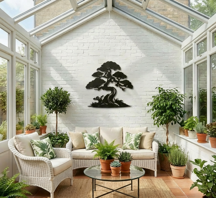 Japanese-inspired bonsai metal wall decor displayed on a white brick wall in a bright sunroom filled with indoor plants and white wicker furniture.
