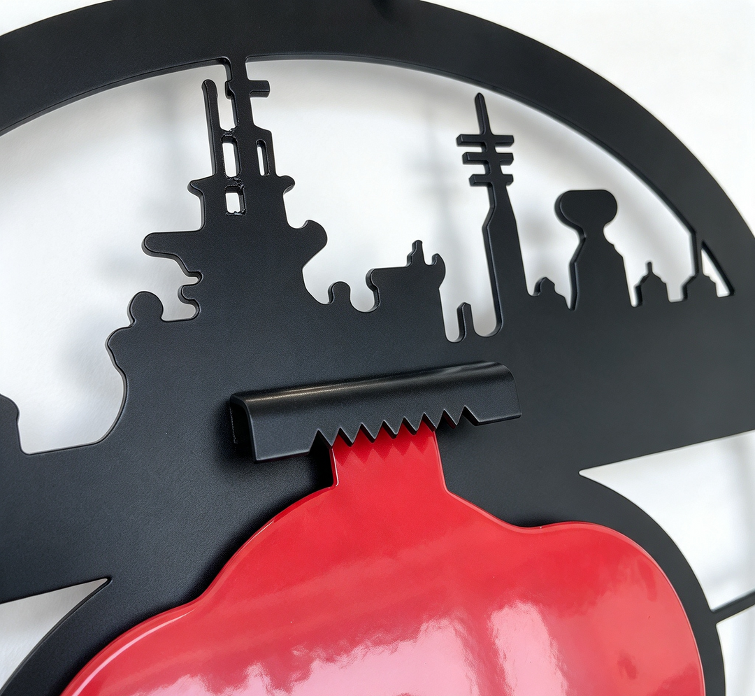 Close-up of a black metal wall art piece featuring a toothed bracket for hanging