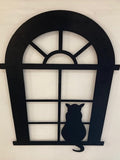 Metal wall decor showing a cat sitting and looking out of an arched window