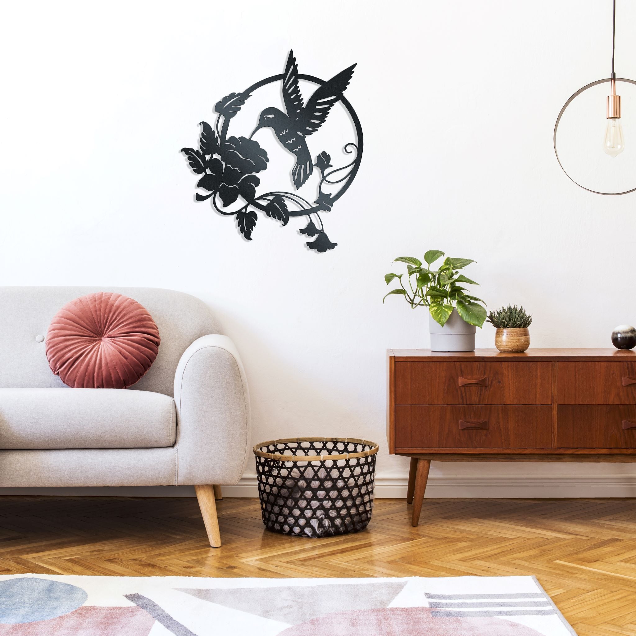 Metal wall decor of a hummingbird hovering above an open flower